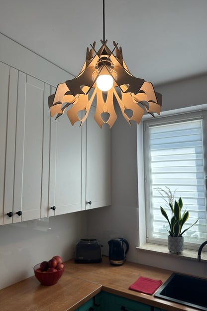 Natural birch wood pendant lampshade with a unique, curved design, hanging in a bright, contemporary kitchen. The soft, diffused light adds warmth to the clean, white space.