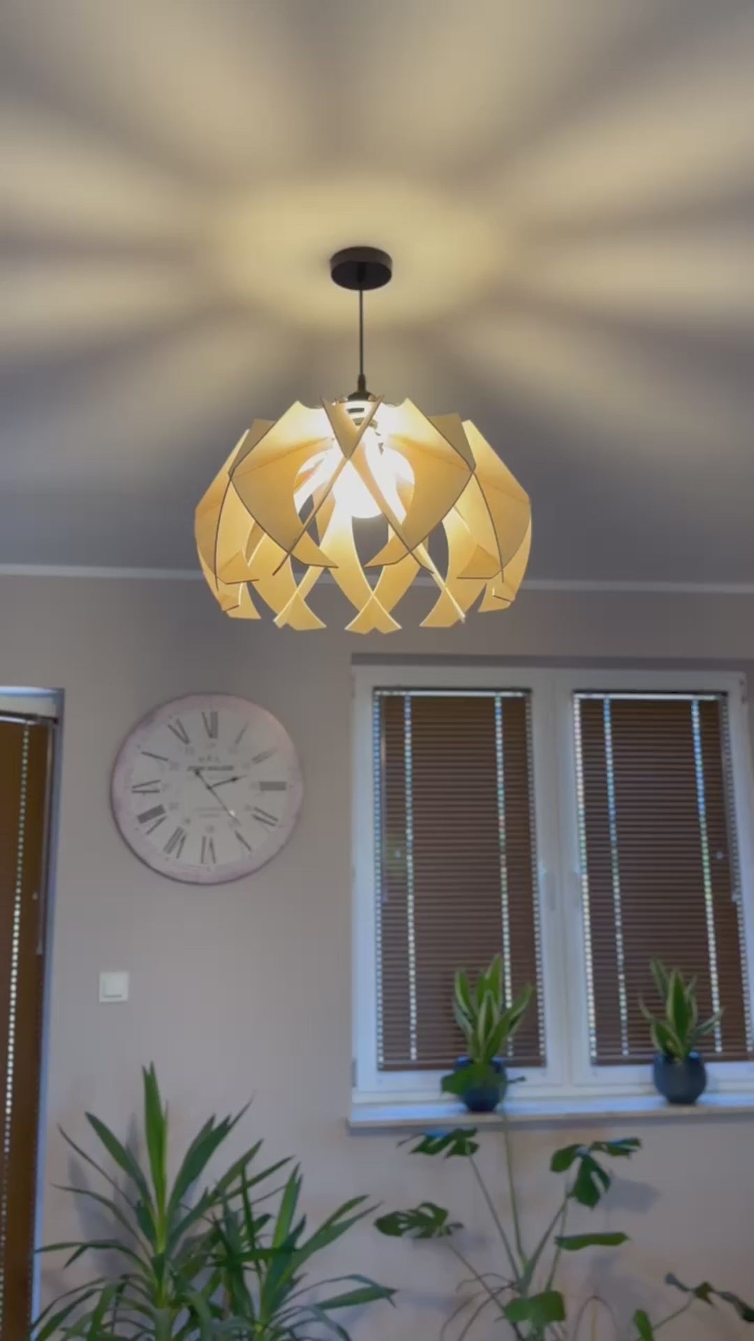 Short video showcasing different views of handcrafted large wooden pendant lamps with a modern flower-like design, highlighting the intricate craftsmanship, eco-friendly materials, and the beautiful light patterns it create.