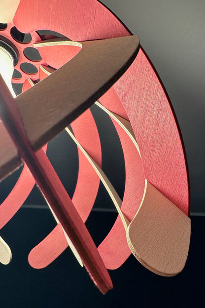 Detailed close-up of the pink and white wooden ribs of the pendant lampshade, focusing on the smooth texture and precise craftsmanship. The light shining through the gaps highlights the elegant design.